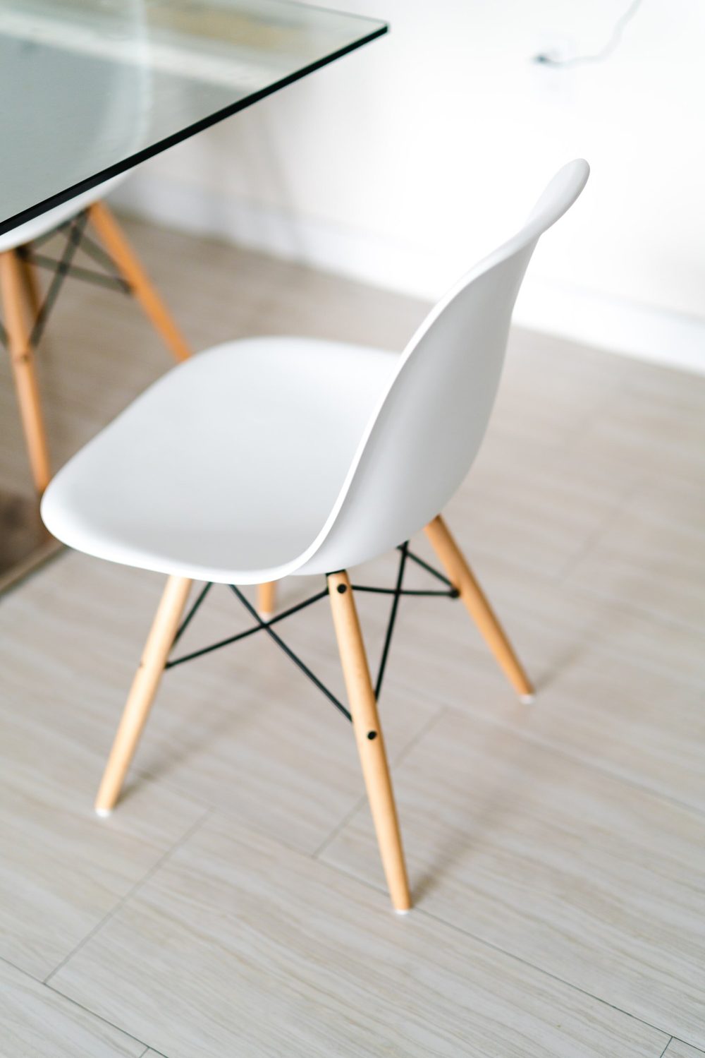 A single white chair beside a glass table